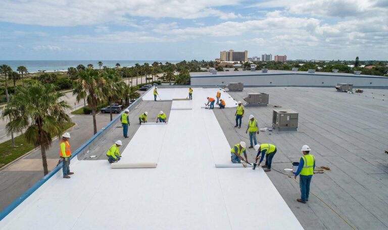 Crew installing flat roof membrane on commercial building