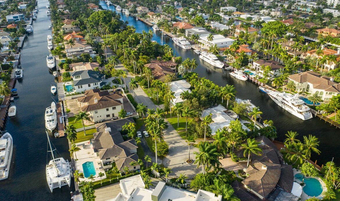 Aerial view of waterfront homes with tile roofs and canals