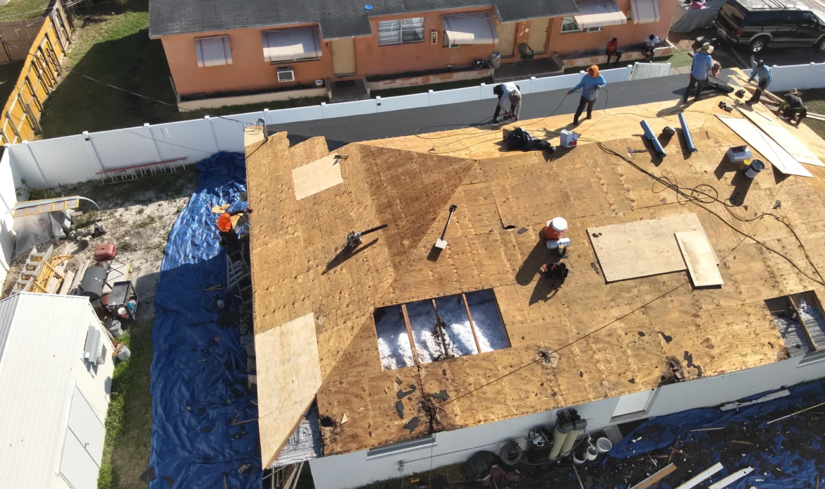 Roof repair work in progress with workers on top of a house.