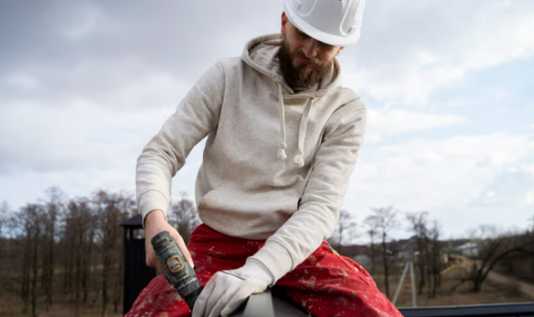 Roofer in protective helmet working on a roof