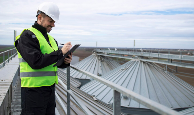 Construction inspector checking roof silos with clipboard
