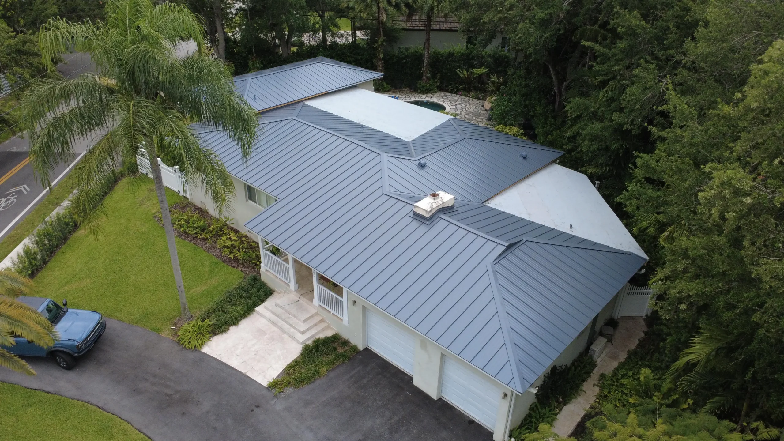 Home with newly installed metal roof and surrounding landscaping
