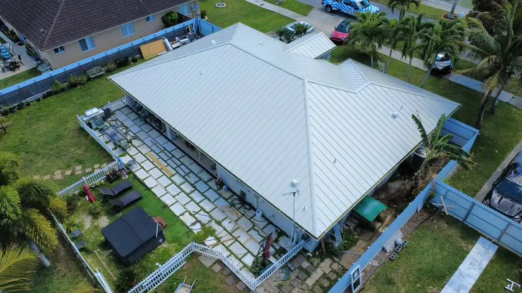 Full property aerial showing metal roof and patio