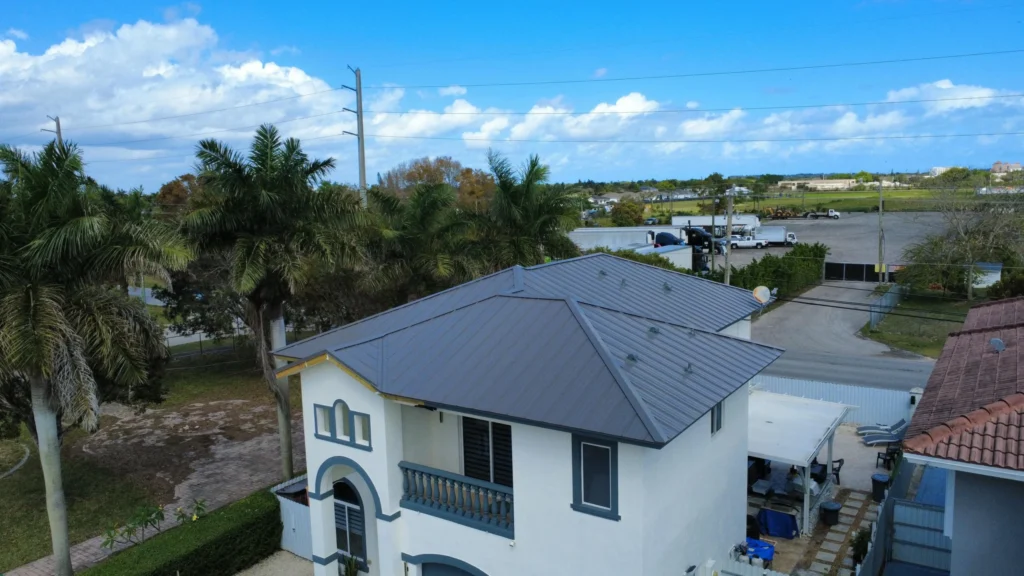Overhead view of gray metal roof with surrounding trees and driveway