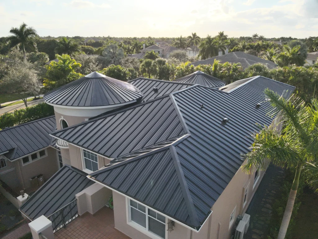 Close-up aerial of a house with dark metal roofing and circular roof accents