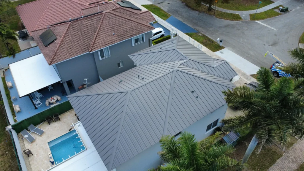 Top view of home with gray metal roof and fenced yard