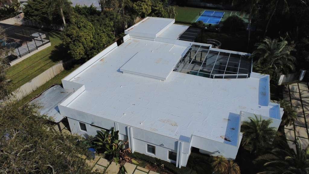 White flat membrane roof with pool enclosure on a Maze Roofing project in Cutler Bay, Florida