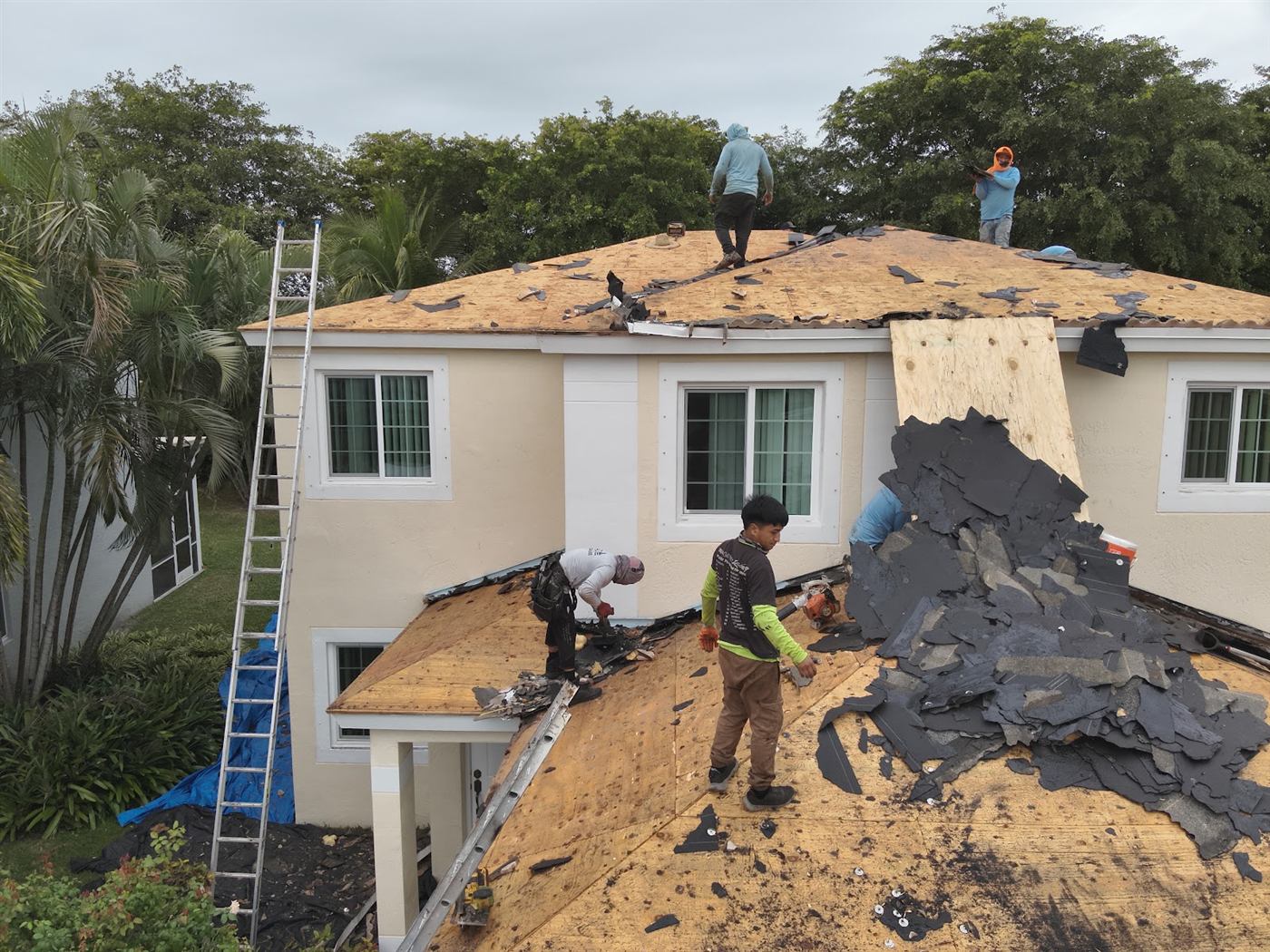 The Maze Roofing crew removing an old roof on a two story South Florida home