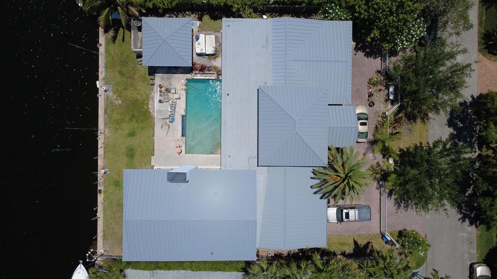 Overhead view of a dove grey standing seam metal roof on a waterfront home in Coral Gables, Miami-Dade County, Florida