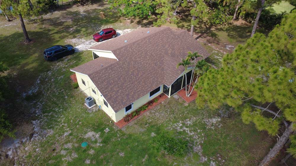 Aerial view of a completed Owens Corning shingle roof in Desert Rose color on a home in West Palm Beach, Florida Aerial view of a completed Owens Corning shingle roof in Desert Rose color on a home in West Palm Beach, Florida