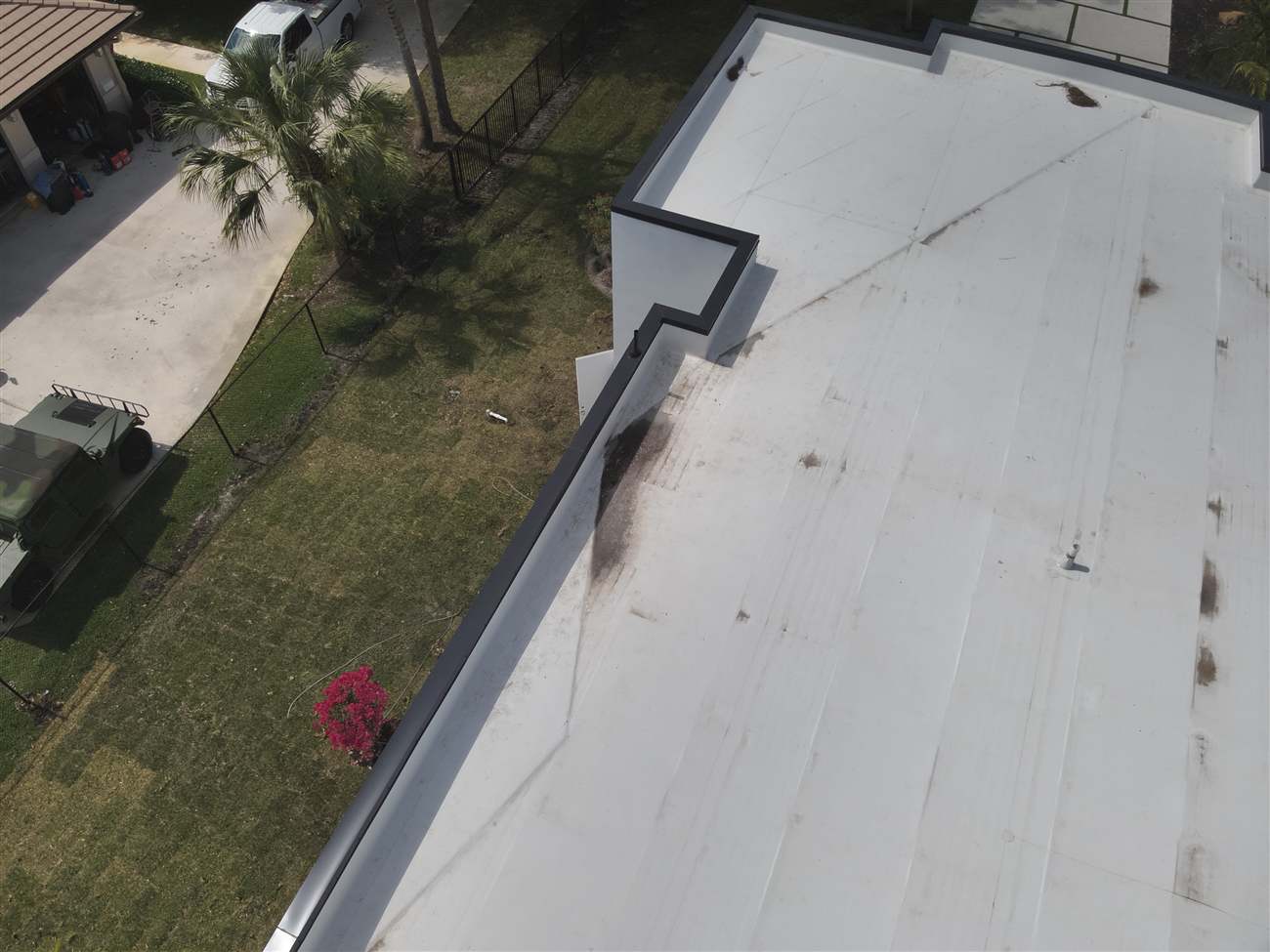 Close aerial view of a new white TPO membrane roof and parapet edge installed by Maze Roofing in Parkland, Florida